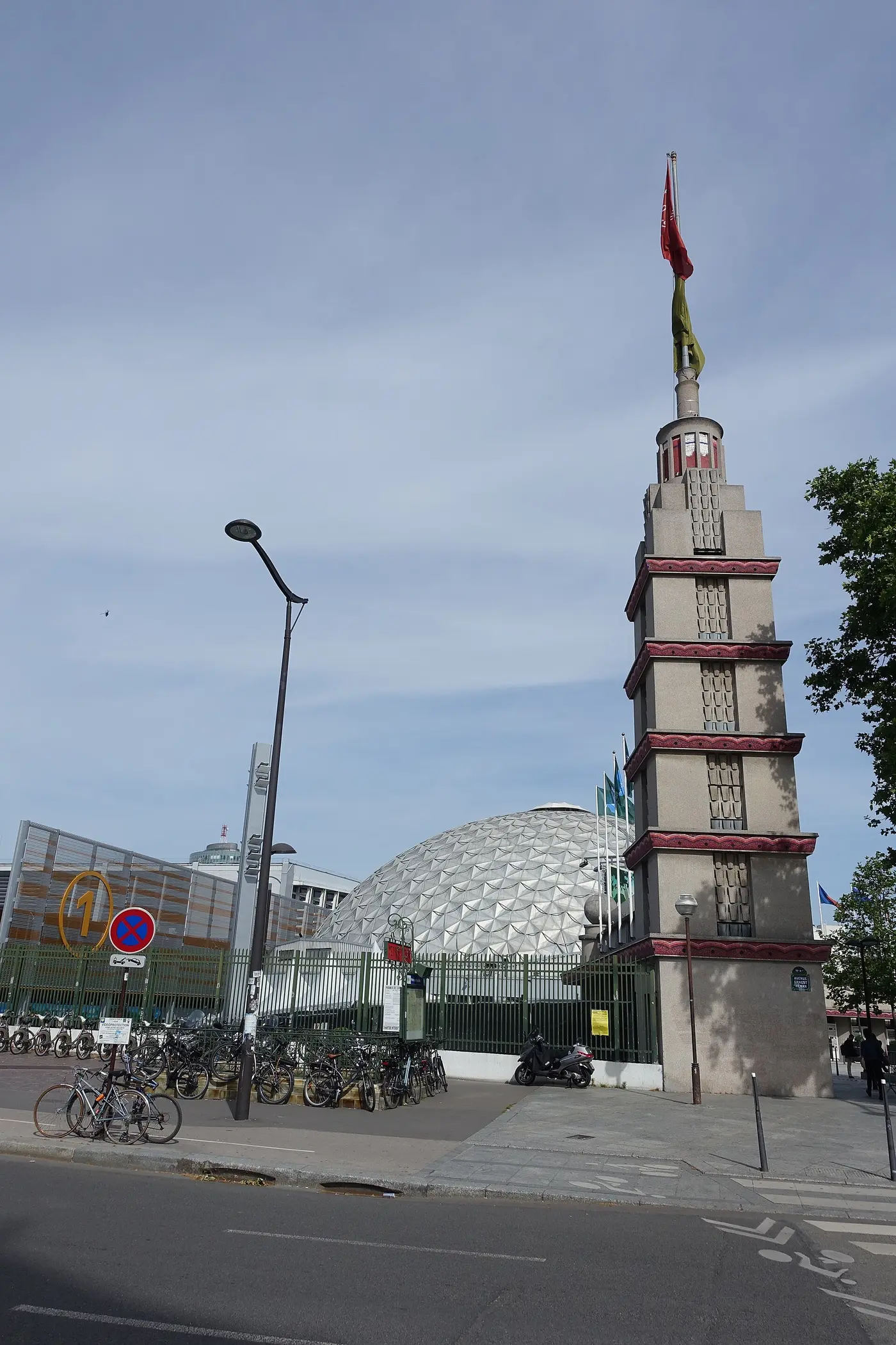 Tour Art déco de l'entrée de Paris Expo Porte de Versailles vue depuis la rue, avec la coupole du Palais des Sports en arrière-plan, Paris 15e.