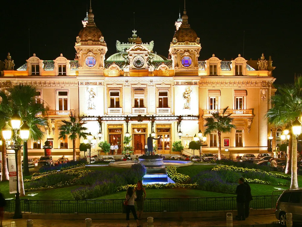Le Casino de Monte-Carlo illuminé la nuit, avec ses jardins et ses palmiers